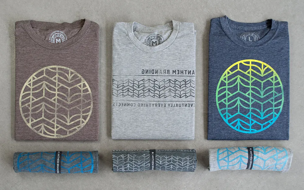Six custom screen printed shirts on a concrete background with the Anthem Branding bookfox logo
